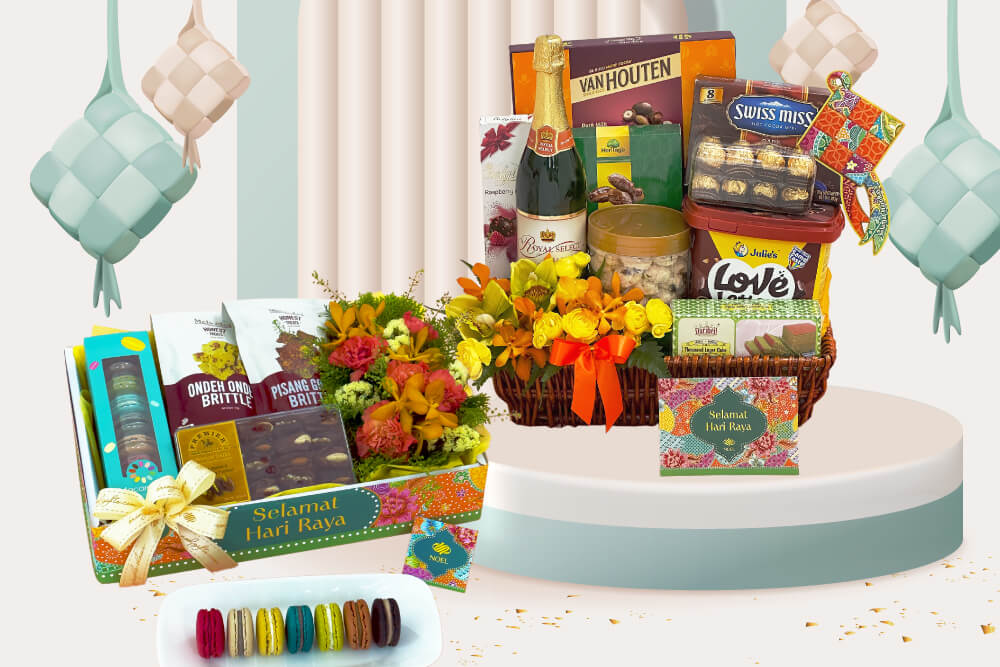 Left: A festive Hari Raya gift set featuring an array of treats and flowers, including Ondeh-Ondeh and Pisang Goreng brittle packets, a box of colourful macarons, and a lush bouquet of flowers.

Right: A festive Hari Raya gift basket filled with a variety of gourmet items, including Van Houten chocolate, Swiss Miss hot cocoa mix, Julie's Love Letters, and Marich chocolate nuts.
