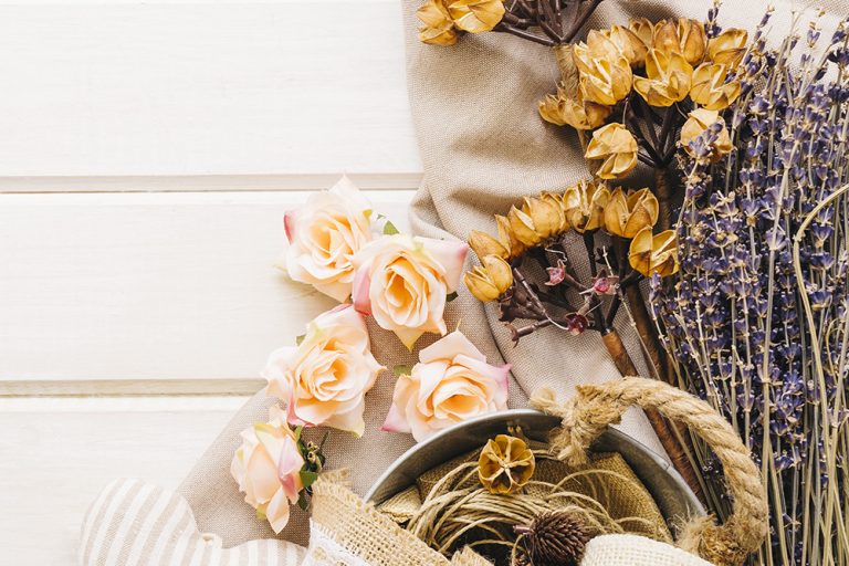 A soft-toned image of dried flowers arranged on a neutral background. This visual represents the process of preserving fresh flowers, the topic of the blog.